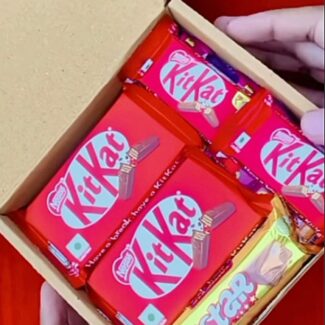 Box of red-wrapped KitKat chocolate bars arranged in a wooden box.