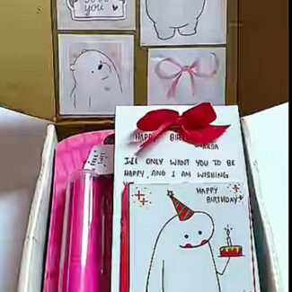 Gift box with greeting cards showing cute animal drawings, including a cat and a bear, and a birthday card with a red bow on top of the box.